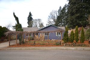 A blue house with trees in front yard